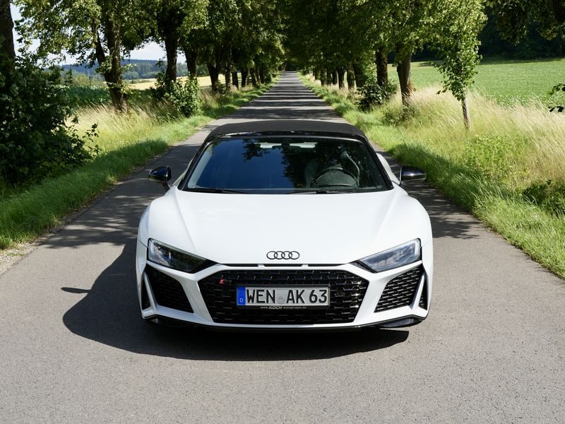 White Audi R8 Spyder on a tree-lined country road in Bavaria